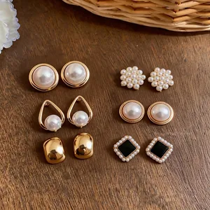 Elegant French style pearl and gold-plated stud earring set displayed on a wooden surface