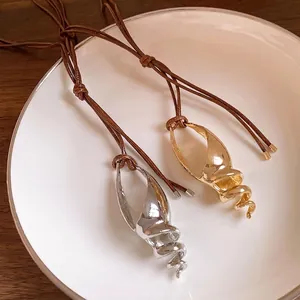 Collane con ciondolo a conchiglia cava con cordino marrone, opzioni oro e argento.