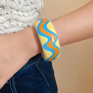 Détail d'un bracelet en résine à motif ondulé vibrant porté au poignet, style rétro