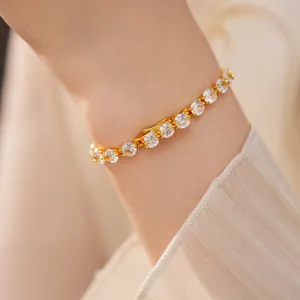 Close-up of elegant 14k gold-plated tennis bracelet with round cubic zirconia on wrist