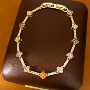 Detailed macro view of a luxury 14k gold plated clover bracelet with multi-colored zircons