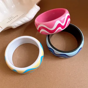 Gros plan de joncs en résine vibrants aux motifs ondulés colorés sur une surface texturée