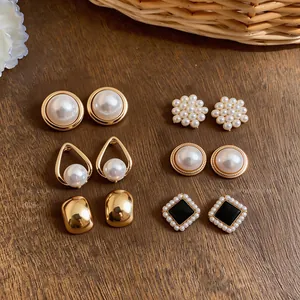 Detailed view of six pairs of gold-finish French style pearl and black enamel earring set