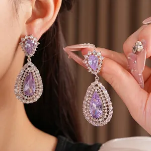 Luxurious purple zircon water drop hollow earrings with silver needle on Asian model