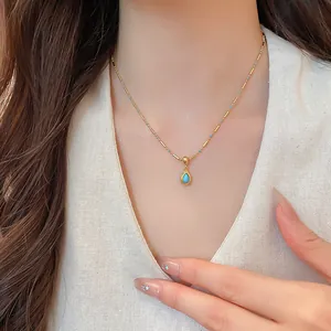 Detaillierte Aufnahme einer goldenen Halskette mit blauem Tropfenanhänger, 18k Vergoldung.