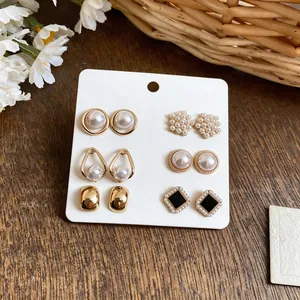 Detailed view of elegant 6-pair French style pearl and gold earring set on white display card