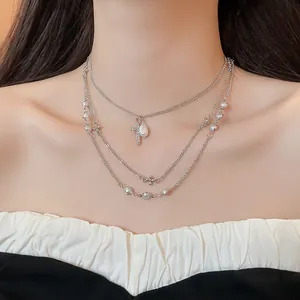 Elegante dettaglio di una collana multistrato in argento con perle e croce pendente
