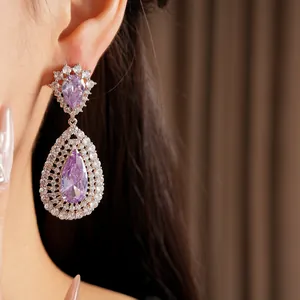 Macro view of luxury purple zircon water drop earrings with intricate lattice design