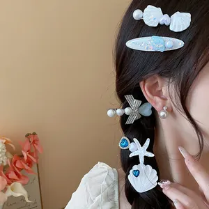 Detail view of exquisite pearl shell and starfish hair clips on a woman's braided hair.