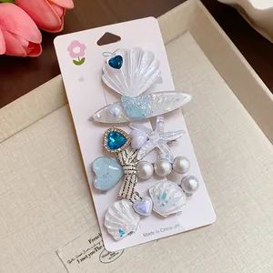 Close-up detail of iridescent resin starfish and shell hair clips with imitation pearls