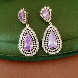 Detail of elegant purple zircon waterdrop earrings with hollow design and silver needles.
