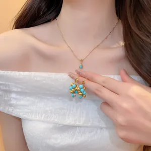Nahaufnahme eines 18k vergoldeten Halsketten- und Ohrring-Sets an einem Modell.