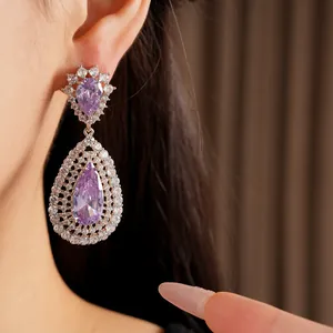 Detailed macro view of elegant hollow teardrop earrings featuring central purple zircon stones