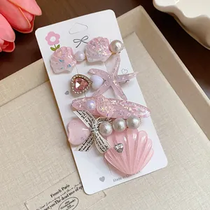Detailed view of pink resin hair accessories with starfish, shells and pearls on a card