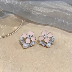 Detailed close-up of pink enamel floral earrings with pearls and zirconia