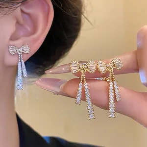 Detailed view of 14k gold plated zircon bow-knot drop earrings featuring elegant tassels.
