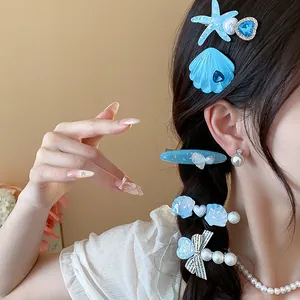 Close-up detail of blue starfish and shell resin hair clips on a braided hairstyle