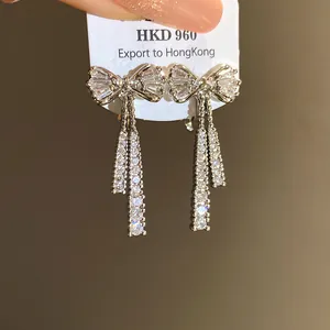 Detail of elegant zircon bowknot tassel earrings with premium 14k gold plating finish