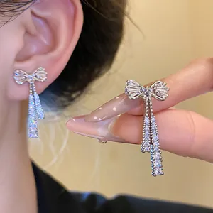 Detailed view of elegant silver bow earrings with shimmering zircon tassels for women