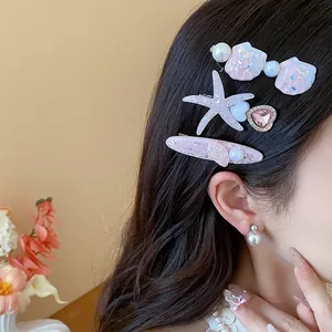 Close-up of resin starfish and seashell hair clips with pearls on model's hair