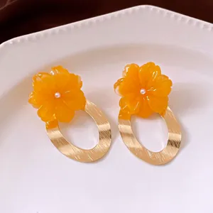 Luxury orange resin flower earrings with gold oval hoops and pearl center