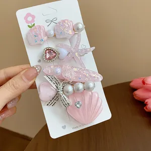 Macro view of pink resin starfish and seashell hair clips decorated with pearls and glitter