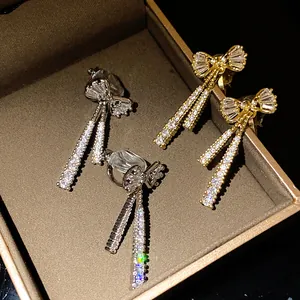 Close-up of 14k gold plated bowknot clip-on earrings with shimmering cubic zirconia stones.