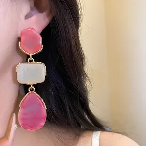 Detail view of vintage resin pendant earrings with pink and cream segments