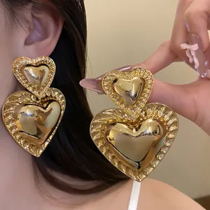 Large vintage-style gold double heart drop earrings for women with smooth finish.