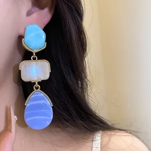 Detailed close-up of vintage resin drop earrings featuring blue, cream, and purple geometric pendants