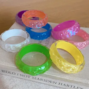 Close-up of colorful resin bangles with irregular concave-convex texture on a book base