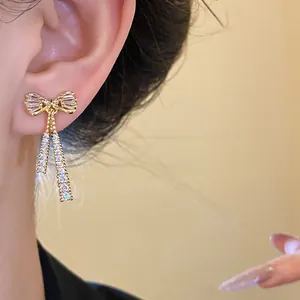 Elegant detail of 14k gold plated bow-shaped ear clip featuring sparkly cubic zirconia