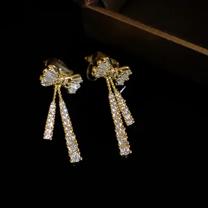 Detailed macro shot of 14k gold plated bow earrings with dangling cubic zirconia
