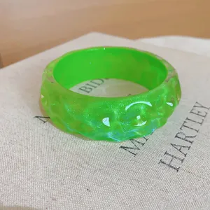 Detailed view of a vibrant green resin bangle with a unique irregular bumpy texture.