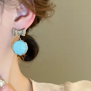 Sweet Korean style silver bow drop earrings featuring a light blue round pendant detail