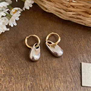 Elegant French style gold hoop earrings with textured silver waterdrop pendants