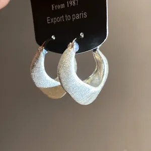 Macro view of 18K gold plated hoop earrings featuring a vintage brushed finish