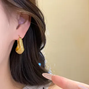 Close-up detail of vintage brushed 18K gold plated round earring on a model's ear