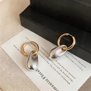 Elegant French style teardrop hoop earrings with silver pleated metallic texture on gold hoops