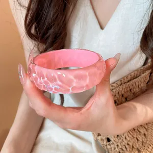Pink resin bangle with irregular textured surface for a chic summer vacation look