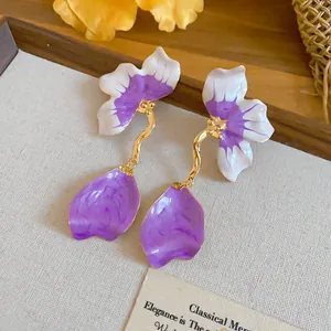 Close-up of elegant French style enamel petal earrings with purple and gold details.