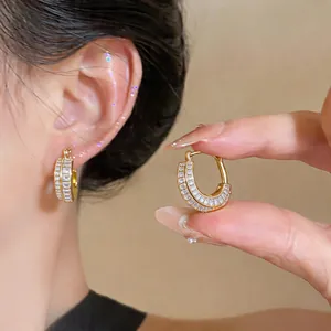 Detailed view showing the elegant gold zircon hoop earrings with a French design