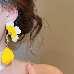 Detailed view of French style yellow and white oil-dripped petal tassel earrings