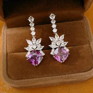 Detailed macro view of elegant purple square-cut zircon earrings in a velvet gift box