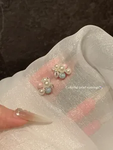 Close-up of dopamine colorful pearl cluster grape stud earrings on sheer fabric