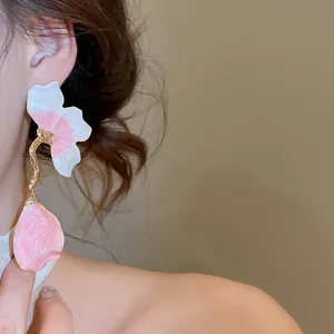 Detail view of elegant French-style petal tassel earrings with pink enamel finish