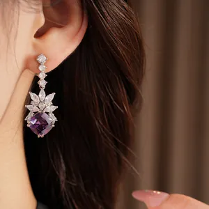Detailed view of an elegant purple zircon earring worn on ear, sparkling high-end jewelry
