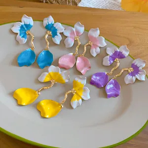 Close-up of elegant colorful enamel petal earrings on a ceramic display plate