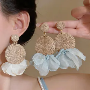 Bohemian chiffon and raffia drop earrings featuring delicate petal-like fabric details.