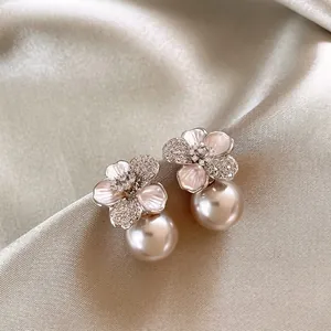 Elegante bloemen parel oorknopjes met roze bloemblaadjes en fijne ingelegde strass